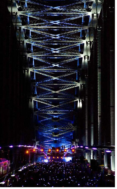 At dusk a smoking ceremony takes place. 90, 44-gallon drums containing damp eucalyptus leaves are lit. These drums are positioned along the entire length of the cycle track on one side and the pedestrian walkway on the other. During this period an evocative and moving soundtrack created by David Page is pumped through the entire sound system.