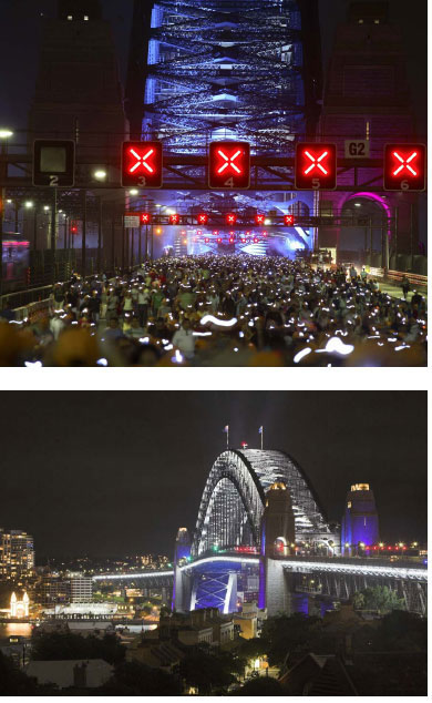 Integral to the daylong celebrations is the lighting of the bridge. In my mind the lighting serves to see the bridge like it has never been seen before. To etch an indelible memory of that day for all who witness it. The celebrations serve to reconnect to our bridges past by building precedence on what has come before, creating iconic images of that day in time. The Bridge is an extra ordinary prop to light, a massive piece of three-dimensional sculpture. We treat both sides of the bridge equally; there is no hero side on this night. In order to maximise the effects of lighting we permeated the air that surrounds the bridge with atmosphere. There are lights on the cycle track and pedestrian walkway, and at key joints punctuating the arch, on top of the pylons and washing up the pylons. Intelligent lights programmed in every conceivable colour. On both sides of the bridge and illuminated at the very end of the night is a line of etched white light that travels along the edge of each approach and across the bridge betweenthe pylons linking north and south.